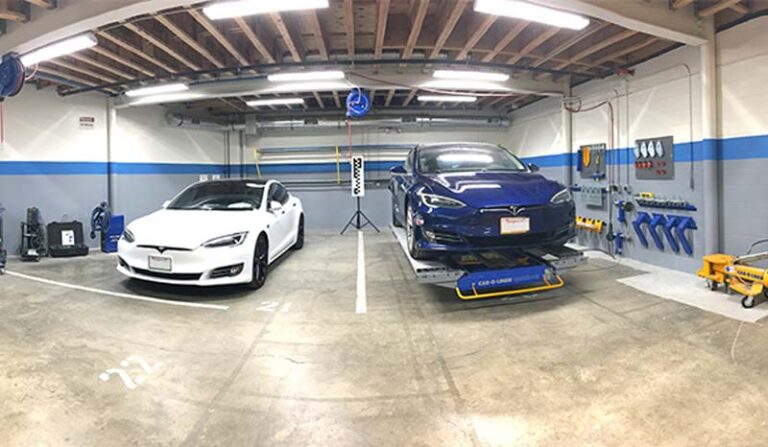 Electric vehicles on structural measuring equipment in the aluminum repair bay at Tony's Body Shop